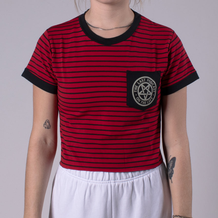 Woman in crimson shirt with black stripes with pocket on chest with LPOTL pentagram graphic