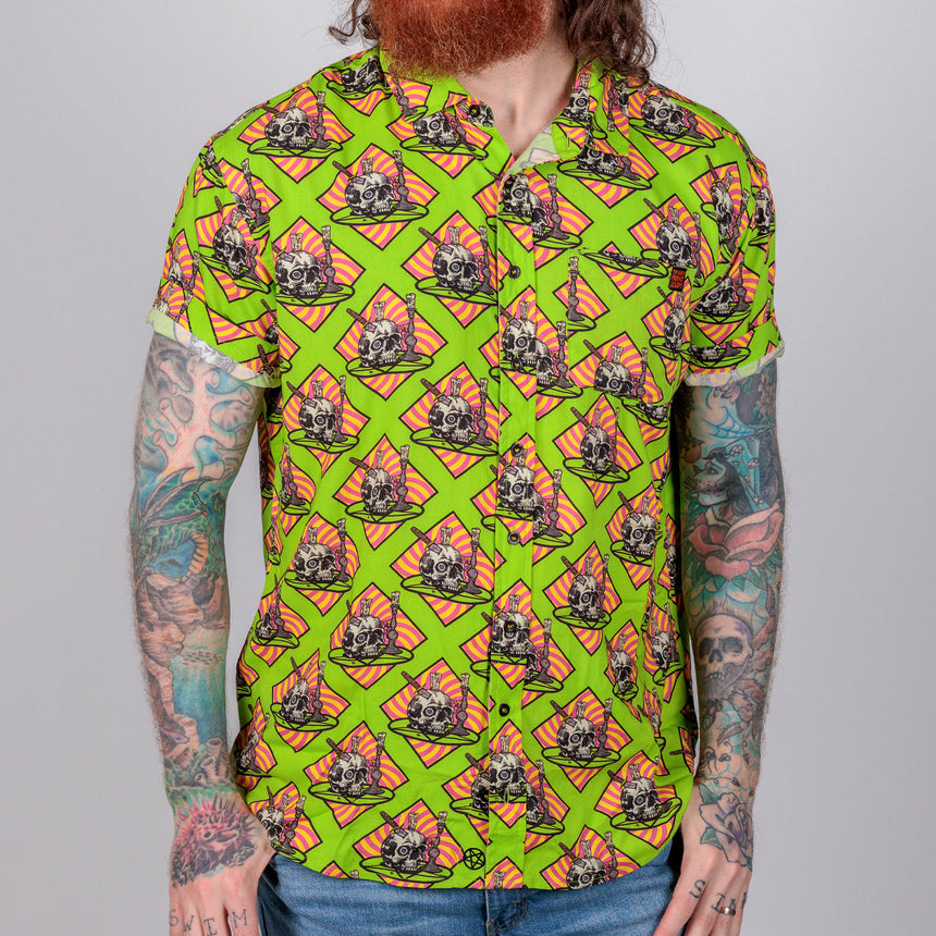 photo of female model wearing occult altar short sleeve buttondown. acid green background with skull on plate on orange background.