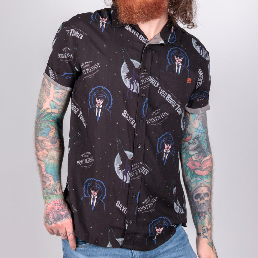 photo of male model wearing point pleasant short sleeve button down, black background with man in suit an winged demon pattern