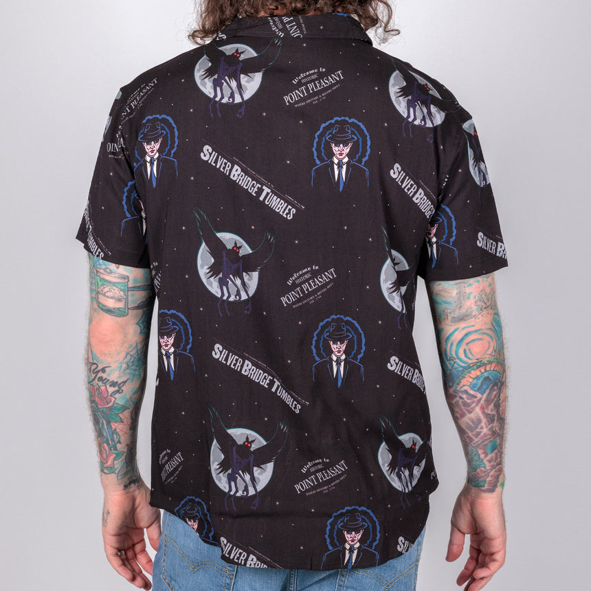 photo of male model wearing point pleasant short sleeve button down, black background with man in suit an winged demon pattern