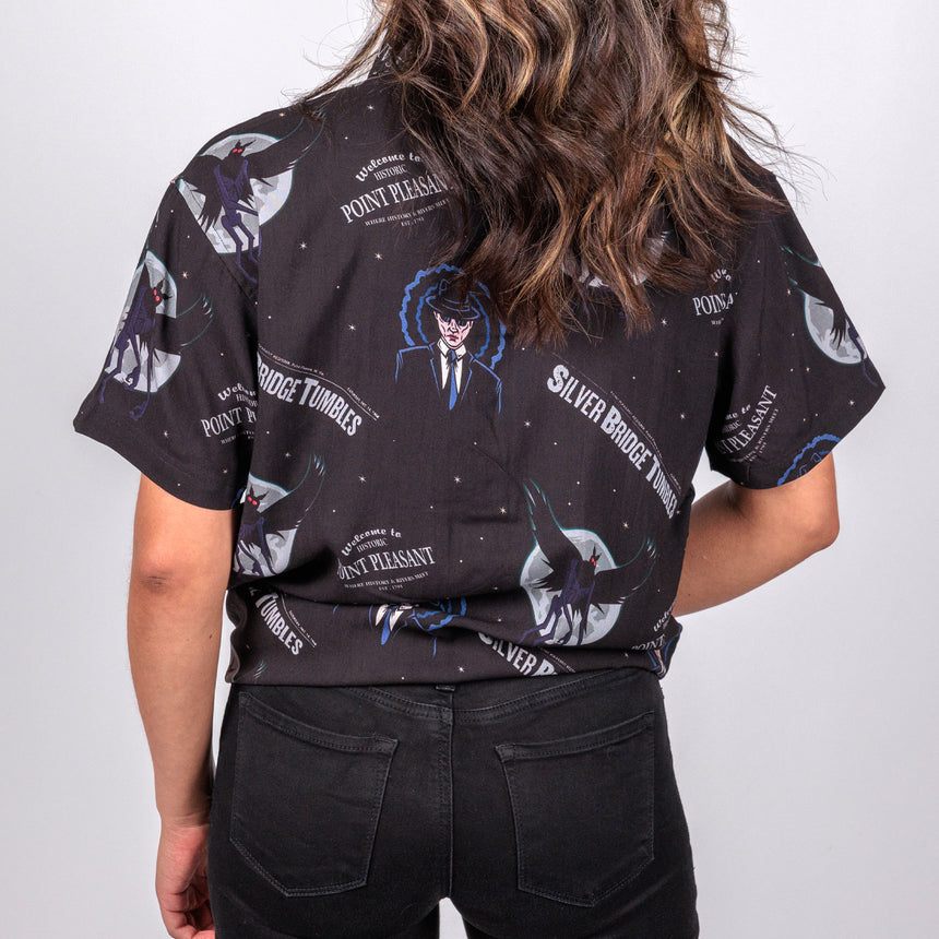 photo of female model wearing point pleasant short sleeve button down, black background with man in suit an winged demon pattern