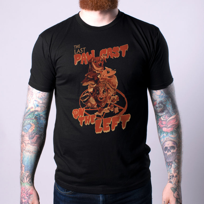 Man in black shirt with orange graphic featuring dogs and pentagram with text "THE LAST PAW CAST ON THE LEFT"
