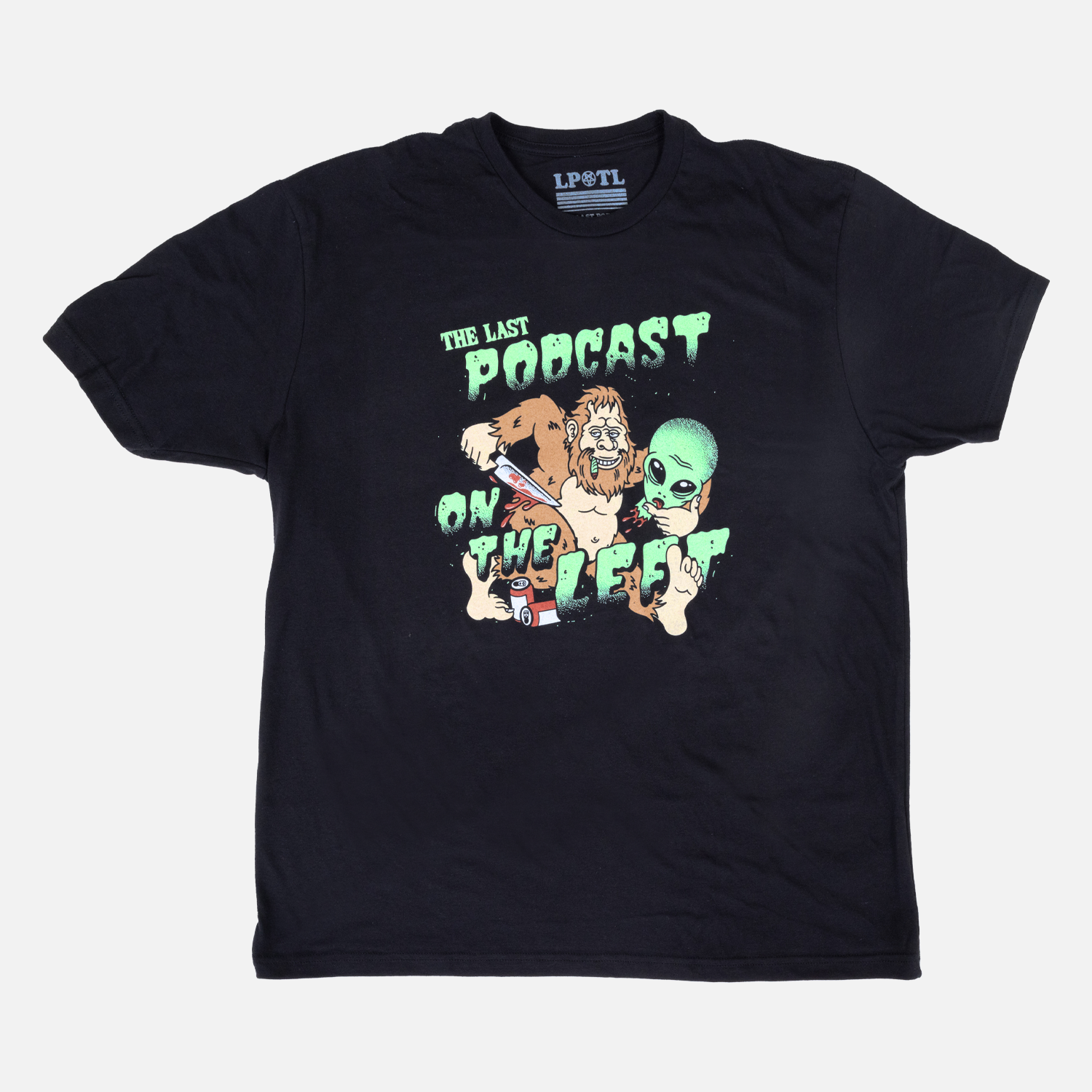Black tee with graphic of bigfoot and alien head with text "THE LAST PODCAST ON THE LEFT"