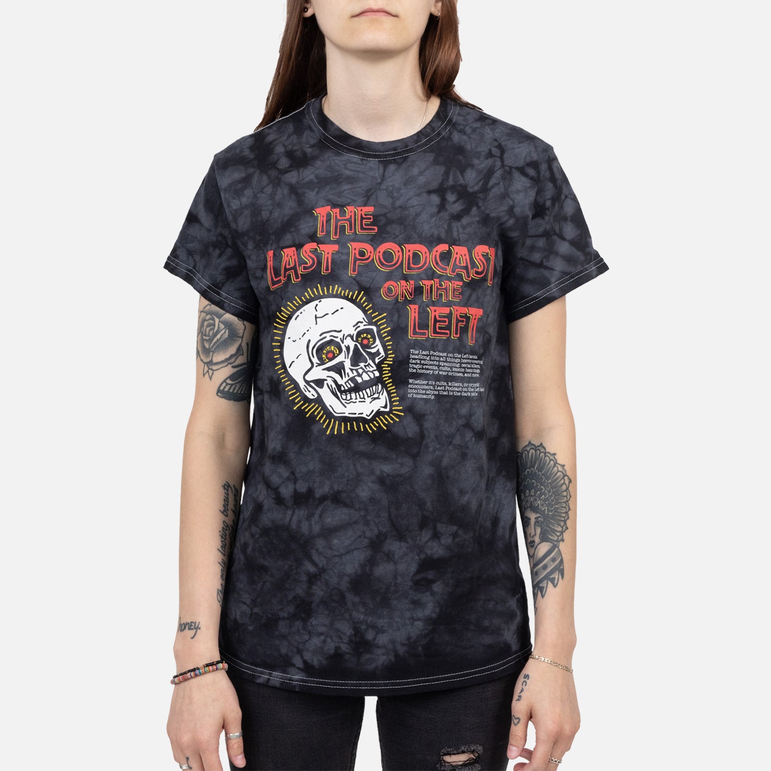 Female model wearing Crystal black tee with graphic of a skull with text "THE LAST PODCAST ON THE LEFT"