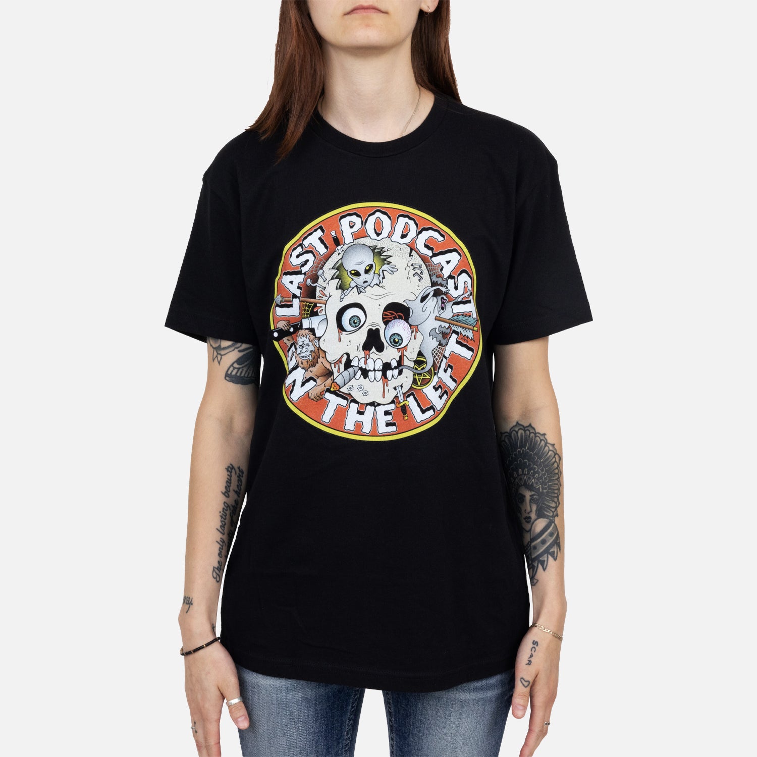 female model wearing black tee with graphic of skull with orange background surrounded by white text "LAST PODCAST ON THE LEFT"
