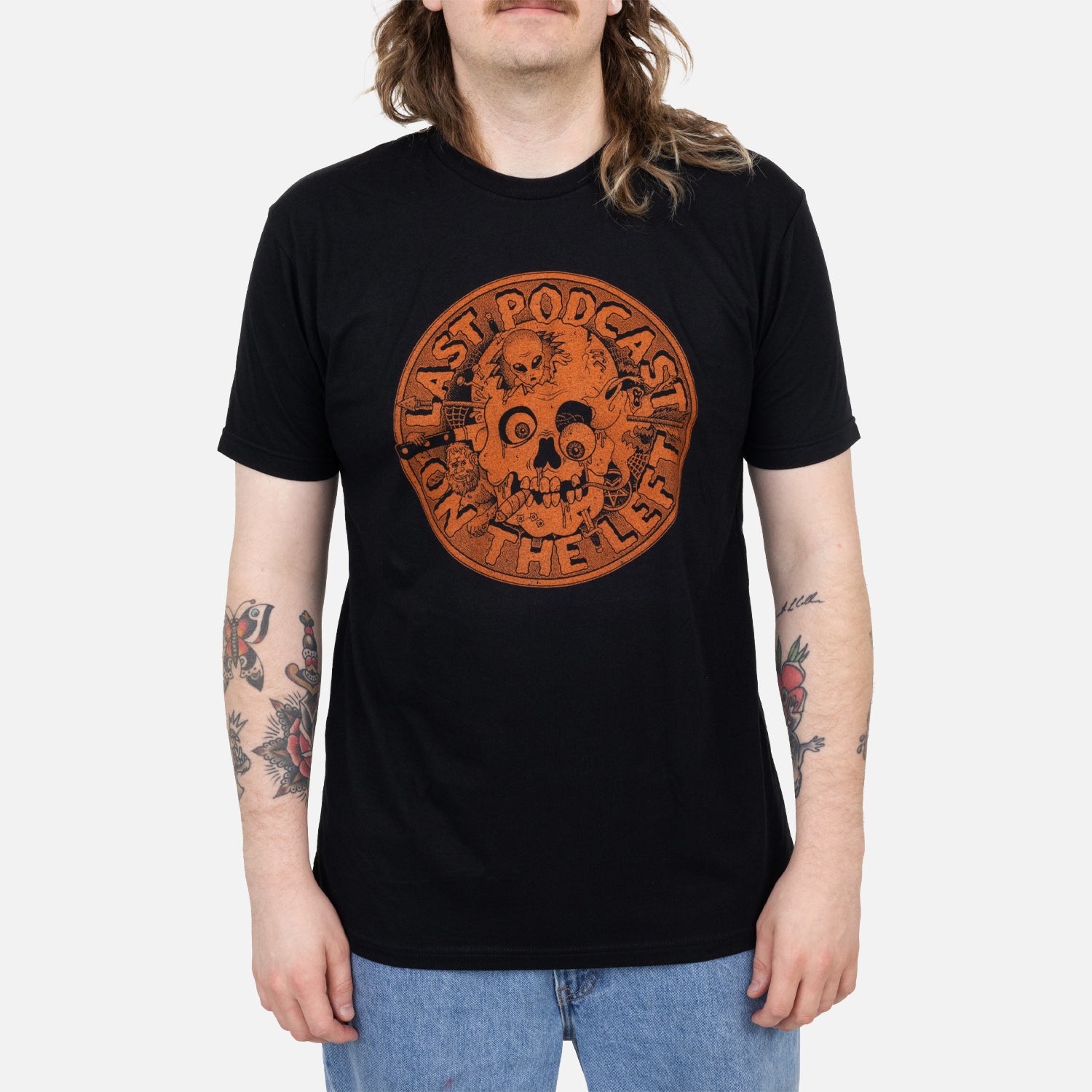 male model wearing Black tee with orange skull graphic with text "LAST PODCAST ON THE LEFT"
