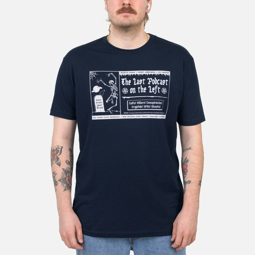 Navy tee with graphic of skeleton dancing next to grave with text "Rise From Your Grave MARCUS PARKS HENRY ZEBROWSKI ED LARSON The Last Podcast on the Left Cults! Killers! Conspiracies! Cryptids! UFOs! Ghosts! WARNING: This show contains mature content which may be considered socking to some. SIDE STORIES EVERY WEDNESDAY NEW EPISODES EVERY FRIDAY ONLY ON SPOTIFY"