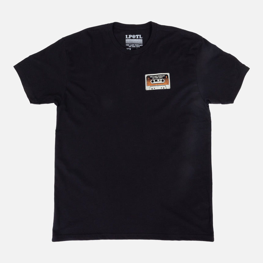 Black shirt with cassette graphic on left chest with text "THE LAST PODCAST ON THE LEFT"