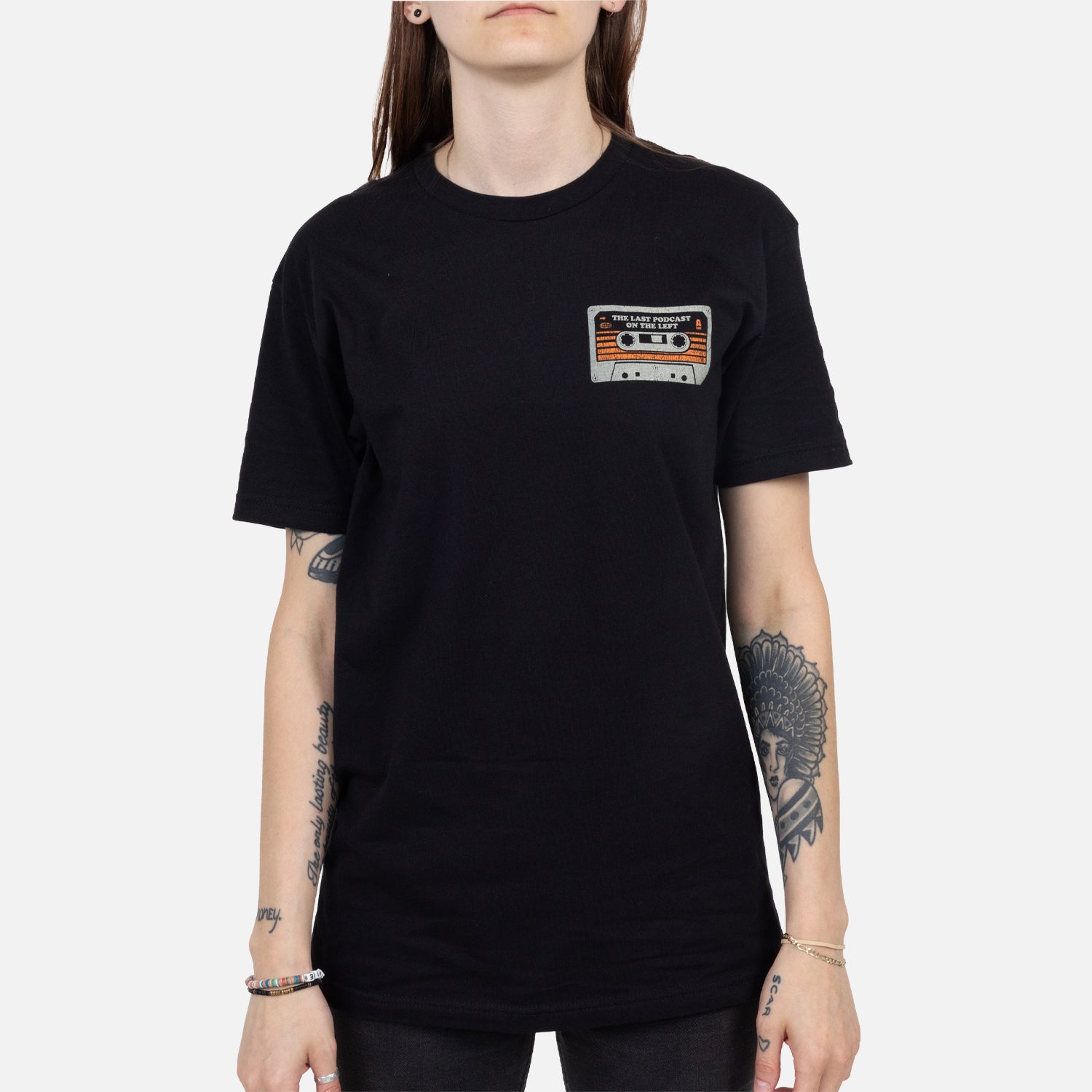 Black shirt on female model with cassette graphic on left chest with text "THE LAST PODCAST ON THE LEFT"