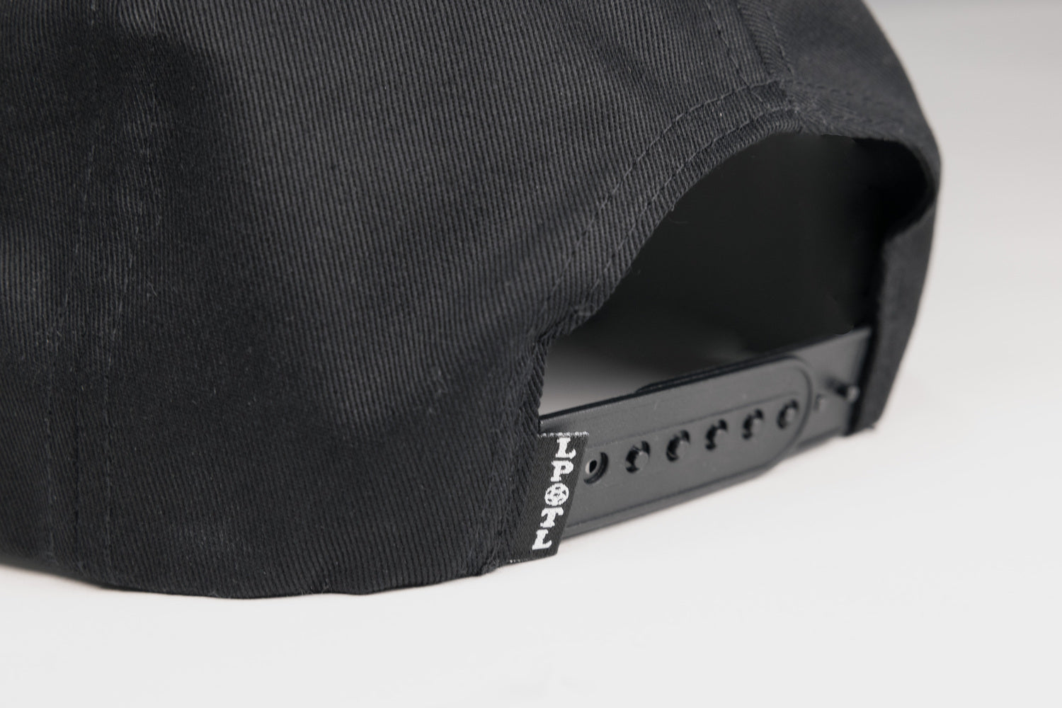 Rear view of black hat showing adjustable strap