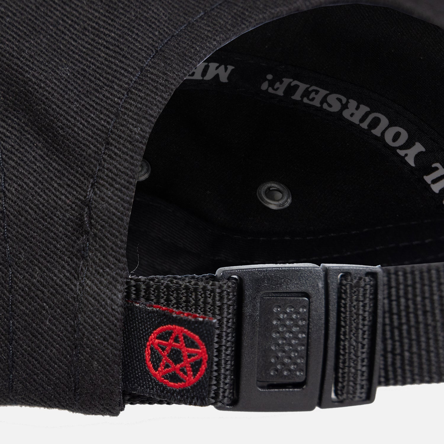closeup of pentagram label on adjustable strap also showing inside taping of hat with white text "Hail Yourself!"