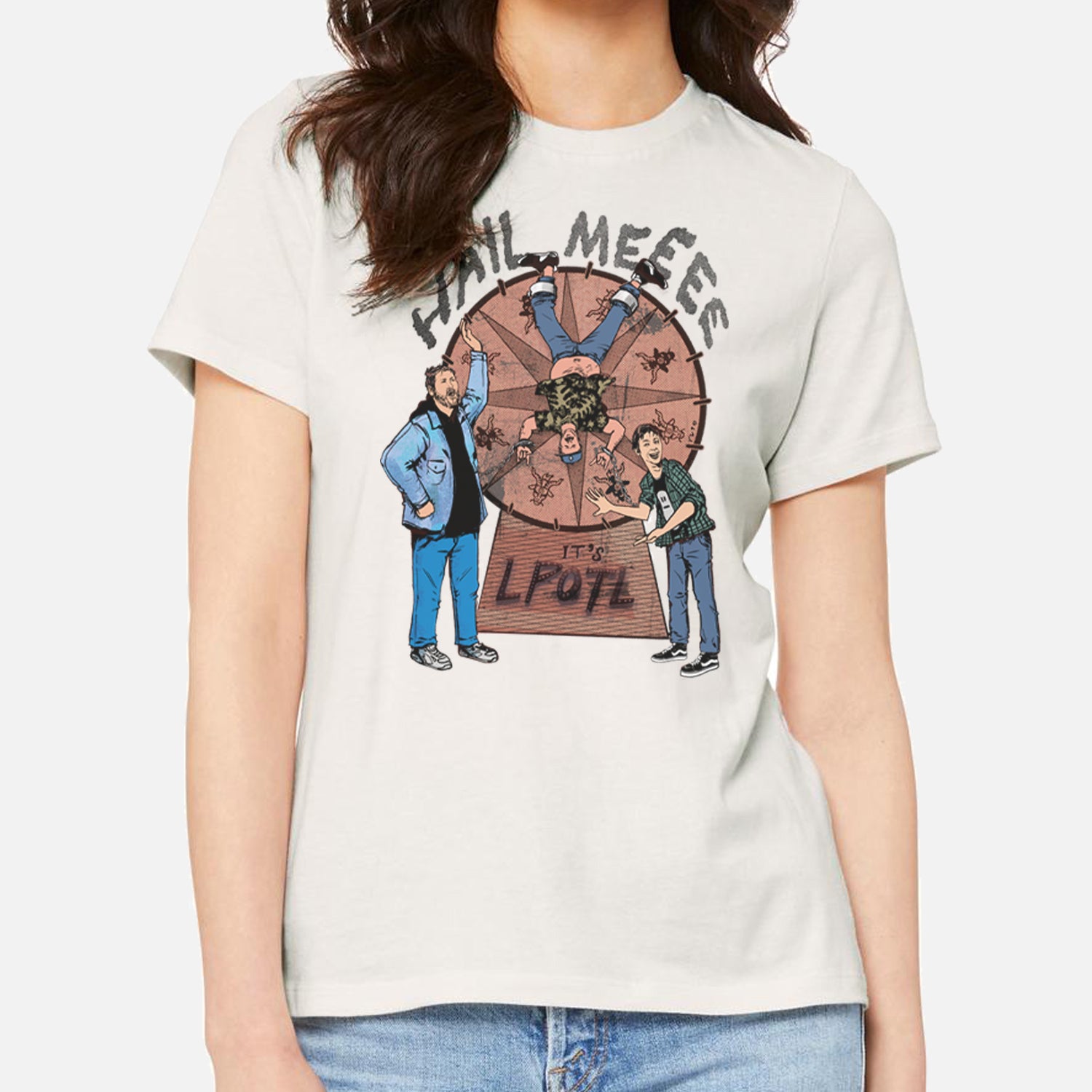Woman in Vintage White shirt with graphic of Man on spinning wheel and HAIL MEEEE IT'S LPOTL text