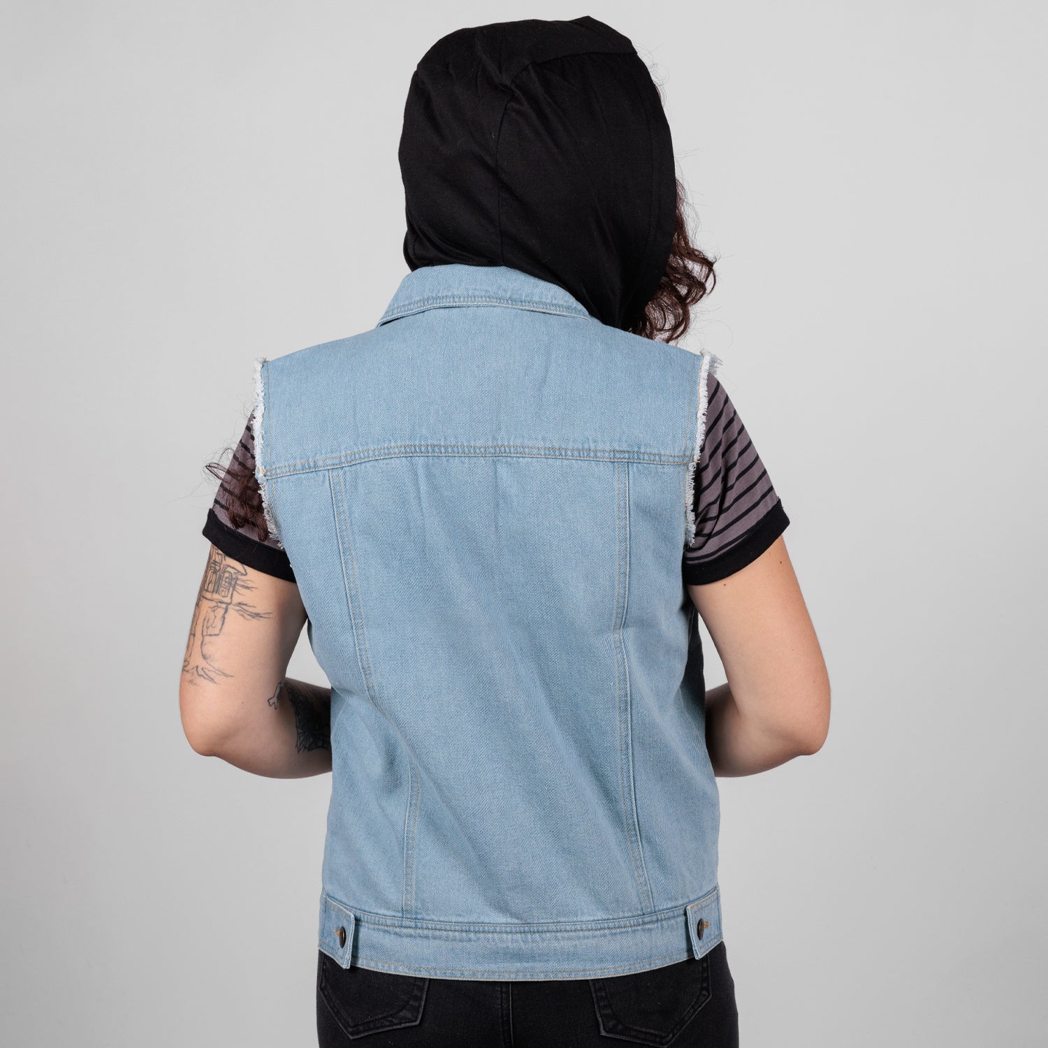 rear view photo of female model wearing hooded denim vest