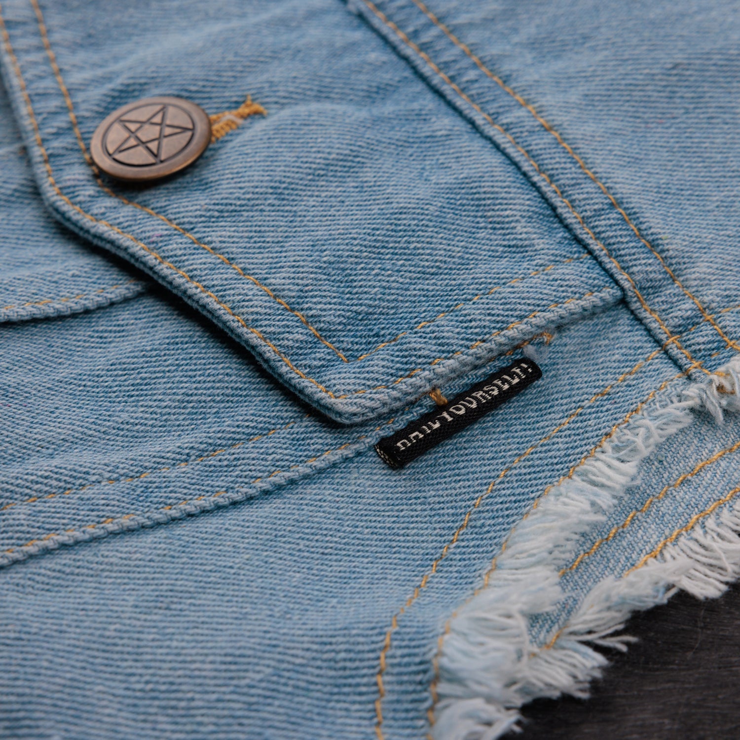 detail photo of left pocket showcasing "hailyourself!" text tag. pentacle button visible.