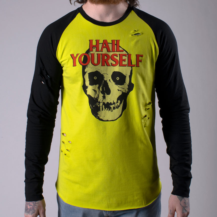 Man in Longsleeve Raw edge shirt with Black sleeves and acid yellow torso with skull graphic on front and dark red HAIL YOURSELF TEXT