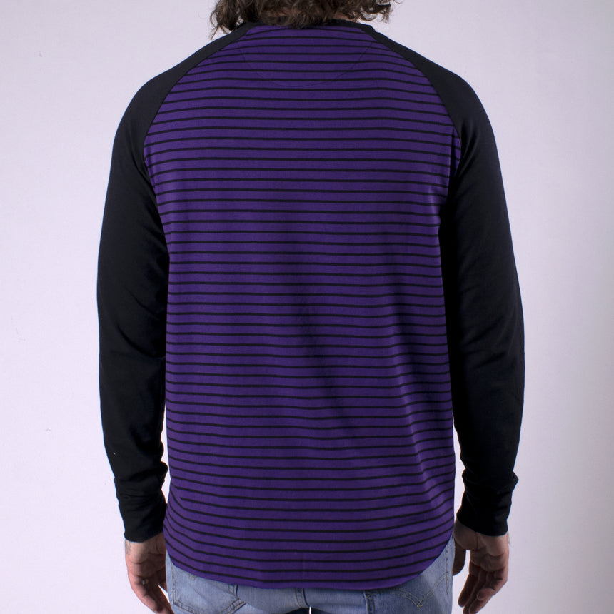 Man in purple shirt with black stripes and black sleeves with pocket on chest that has LPOTL pentagram graphic