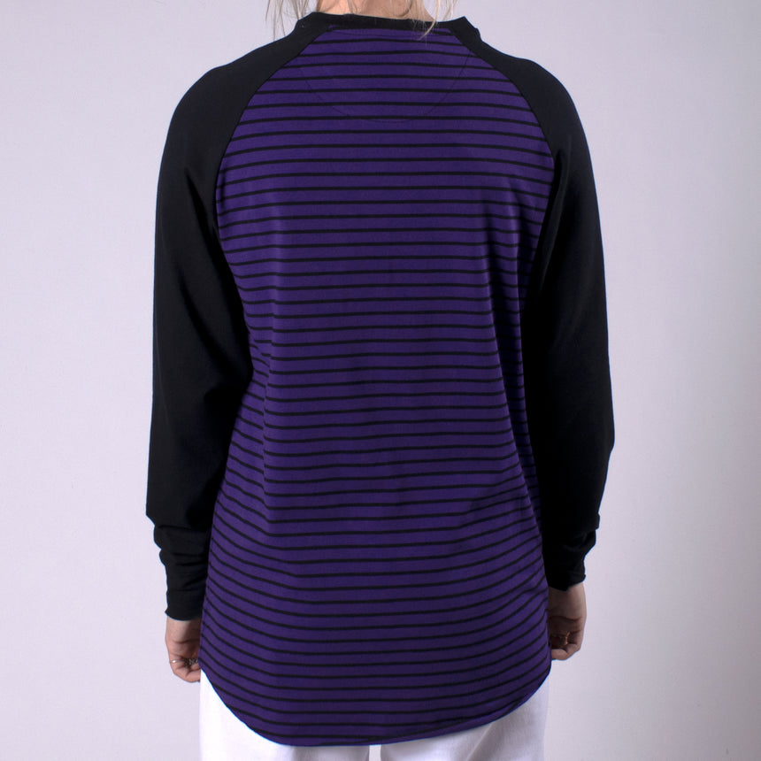 Man in purple shirt with black stripes and black sleeves with pocket on chest that has LPOTL pentagram graphic