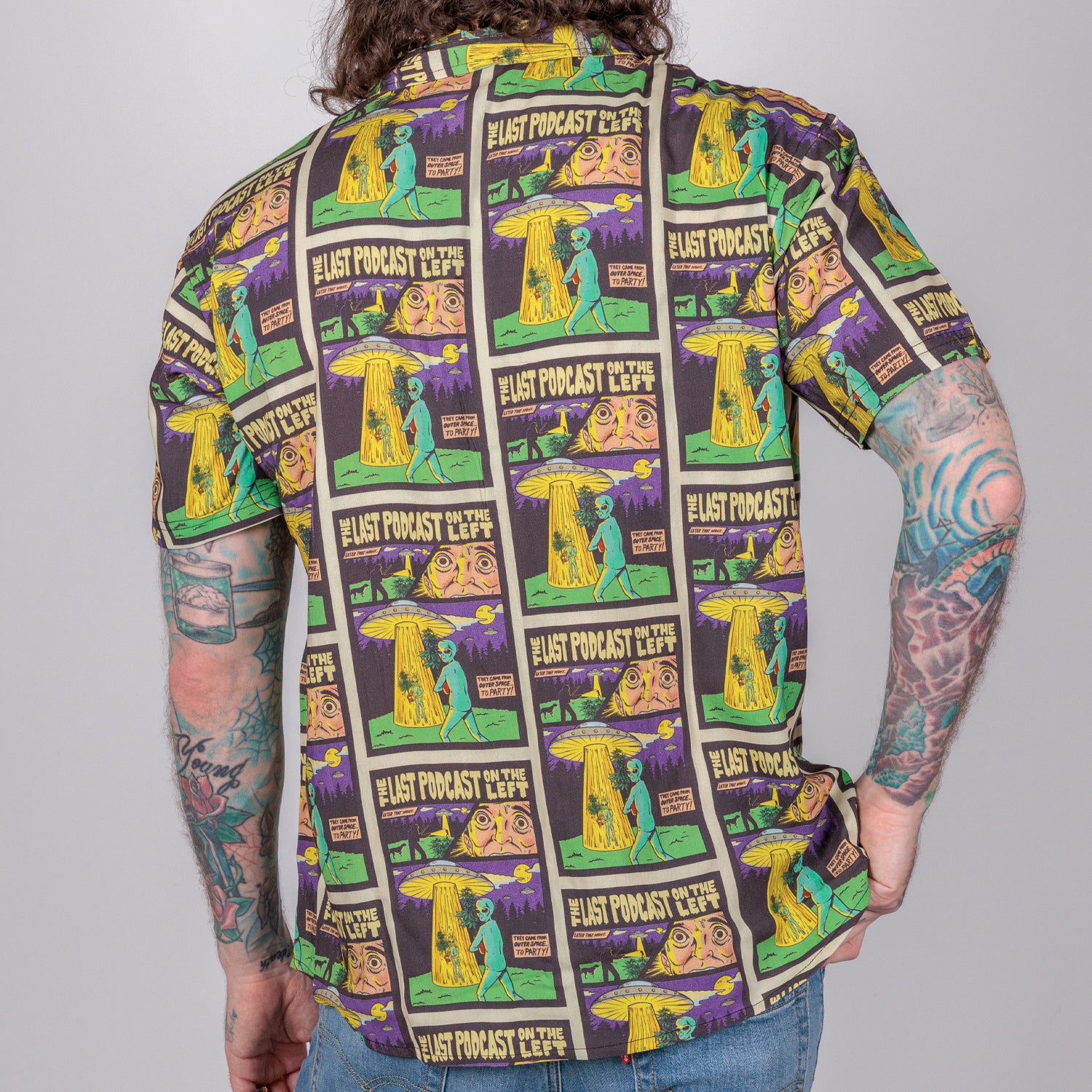 rear photo of male model wearing party time short sleeve button down. comic book background with alien and spaceship