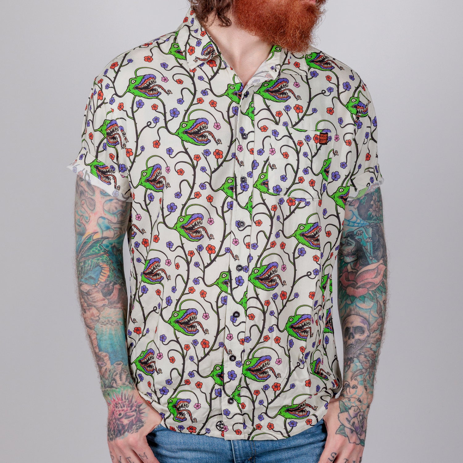 photo of male model wearing man-eating plant short sleeve buttondown in bone color. pattern of man eating plant.