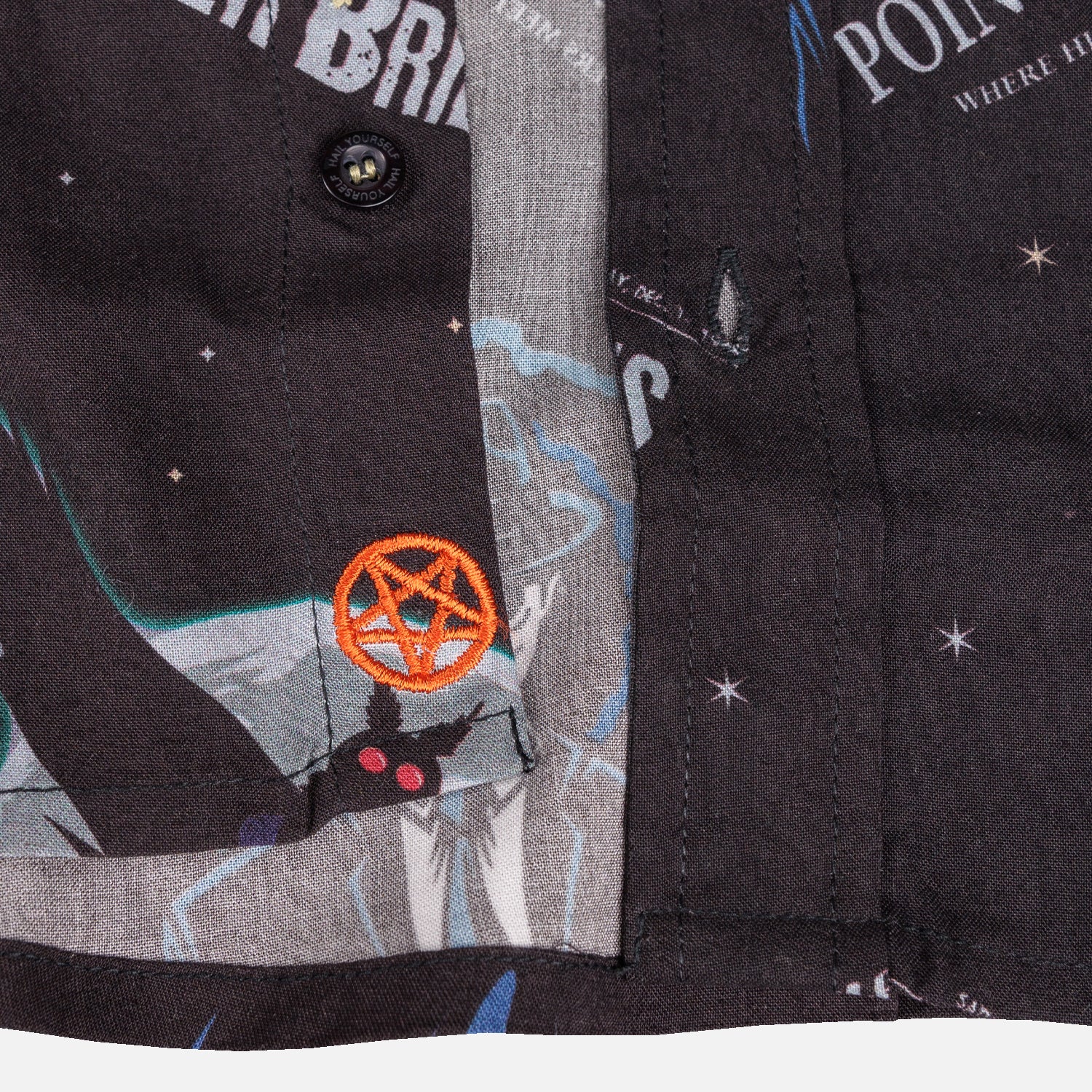 detail photo of button with hail yourself around top. orange pentagram sewn near waist
