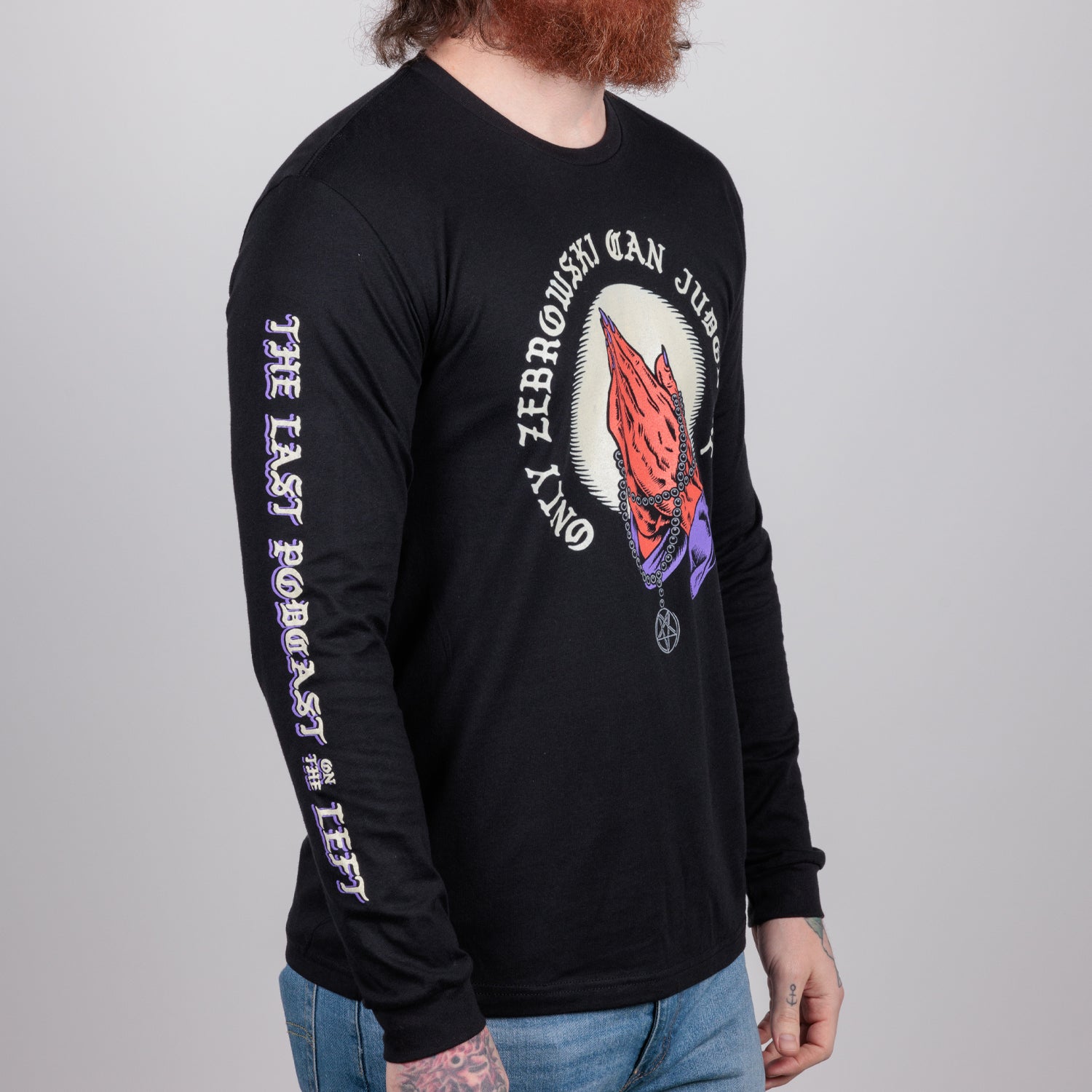 side view of Man in black shirt with praying hands graphic surrounded by text "ONLY ZEBROWSKI CAN JUDGE ME" and text on right sleeve "THE LAST PODCAST ON THE LEFT"