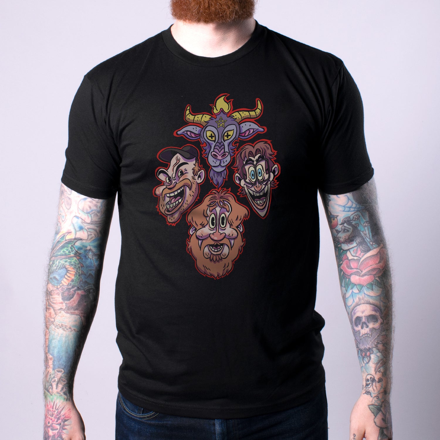 Man in black shirt with graphic of the 3 hosts faces and goats head