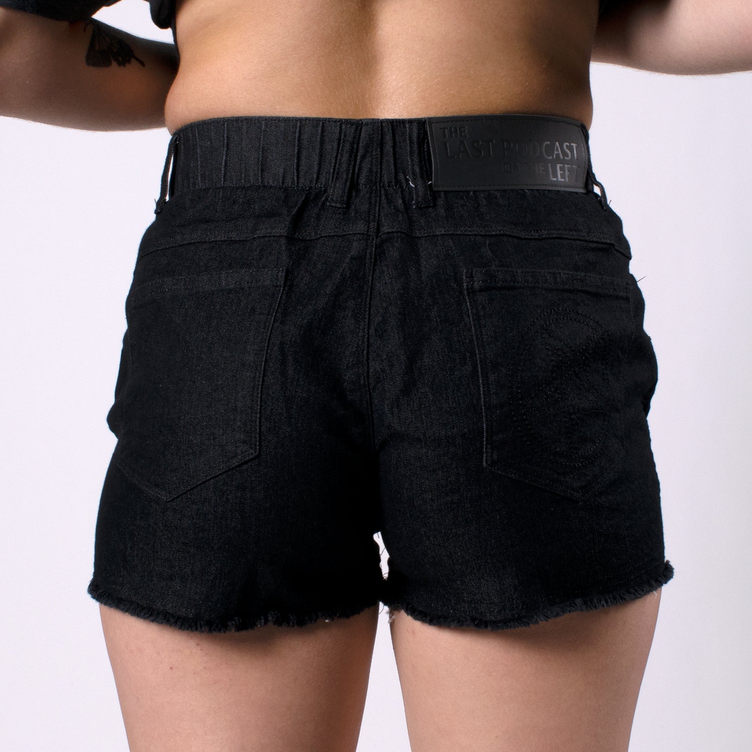 back of black denim short with the last podcast on the left patch